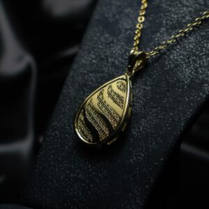 Close-up of an intricately designed gold necklace pendant exuding luxury and elegance.