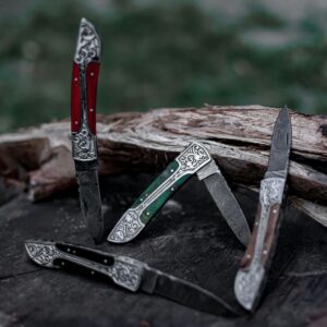 Detailed view of three ornate pocket knives with carved handles on a tree stump outdoors.