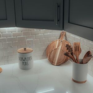 Clean and organized kitchen countertop featuring wooden utensils and stylish containers.