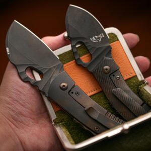 Close-up of compact folding knives in a hand-held carrying case, showcasing modern design.